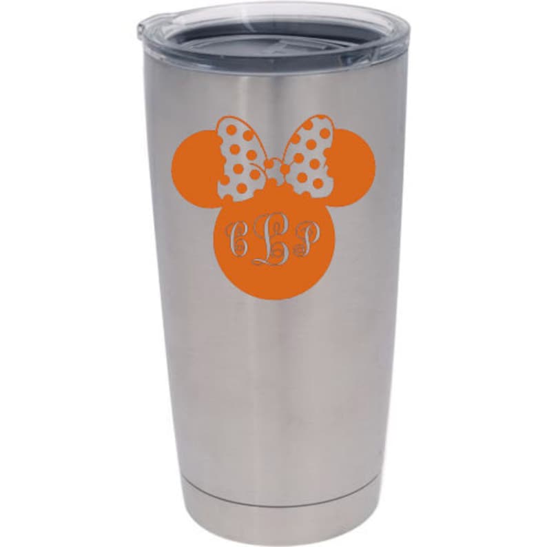 May include: A stainless steel tumbler with a black lid. An orange Minnie Mouse design is on the front, featuring a polka dot bow and the initials "CLP" in a decorative font. The tumbler is designed to keep drinks cold or hot.