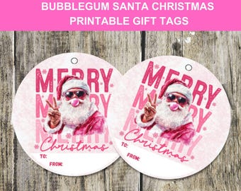 May include: Two round gift tags with a pink and white design. Each tag features a cartoon Santa Claus wearing sunglasses and blowing a bubblegum bubble. The words "MERRY CHRISTMAS" are printed on the tags, along with spaces for "TO:" and "FROM:"