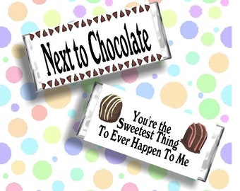 May include: Two chocolate bar wrappers with a white background and black text. The first wrapper says "Next to Chocolate" with a brown triangle border. The second wrapper says "You're the Sweetest Thing To Ever Happen To Me" with a chocolate and pink candy illustration.
