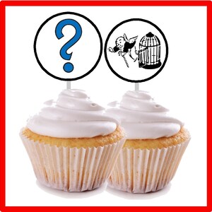 Peut inclure: Deux cupcakes avec du gla&ccedil;age blanc et un point d'interrogation et un homme du Monopoly dans une cage &agrave; oiseaux sur le dessus.