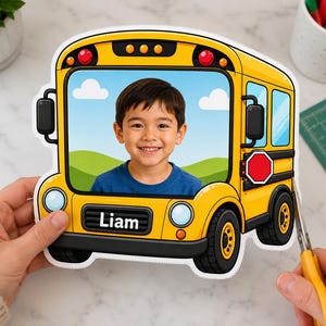 May include: A yellow school bus cutout featuring a photo of a young child in the window, with the name Liam printed on the front bumper. The bus design includes black tires, a red stop sign, and a blue sky background with white clouds.