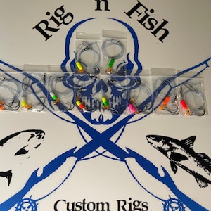 May include: A set of eight fishing rigs in clear plastic bags. Each rig has a clear line, two hooks, and a colorful bead. The rigs are arranged in two rows of four. The bags are labeled "Rig 'n Fish Custom Rigs".