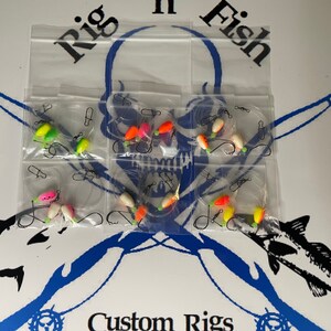 May include: A set of six fishing rigs with colorful beads and hooks, packaged in clear plastic bags. The bags are labeled "Rig n Fish" and "Custom Rigs".