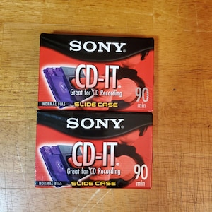 May include: Two red and black Sony CD-IT CD recording cases. Each case features the Sony logo, the text "CD-IT", and "Great for CD Recording". The cases also indicate a 90-minute recording time and "Slide Case".