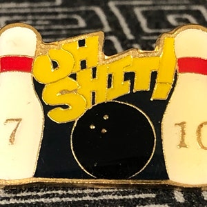 May include: A gold-colored bowling pin with the number 7 on it, a gold-colored bowling pin with the number 10 on it, a black bowling ball, and the words "Oh Sheet!" in yellow letters on a blue background.
