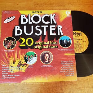 May include: A K-Tel Block Buster 20 original hits original stars vinyl record album cover with a red and yellow gradient background, featuring artist photos, song titles, and a black vinyl record partially pulled out from the sleeve.