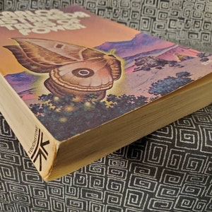 May include: A paperback book titled "The Trials of Power" by Carlos Castaneda. The cover features a large, brown moth with a white spot on its wing, set against a colorful, abstract background.