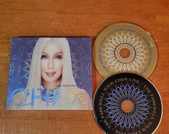 CD de grandes éxitos de Cher con funda y disco extra en directo.