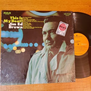 May include: A vintage vinyl record album titled "This Is My Beat!" by Jim Ed Brown. The album cover features a portrait of the artist and the RCA Victor logo. A price sticker is visible on the cover.