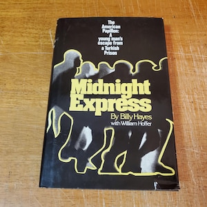 May include: A paperback book titled "Midnight Express" by Billy Hayes with William Hoffer. The cover is black with yellow text and a silhouette design. The subtitle reads "A young man's escape from a Turkish Prison."