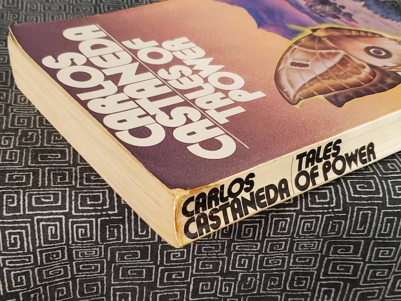May include: A paperback book titled "Tales of Power" by Carlos Castaneda. The cover features a butterfly with a brown and white pattern against a sunset background.