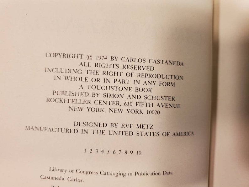 May include: Copyright information for a book published in 1974 by Carlos Castaneda. The book is titled "A Touchstone Book" and was published by Simon and Schuster. The book was designed by Eve Metz and manufactured in the United States of America.
