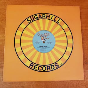 May include: A set of three ceramic mugs with a speckled, matte finish. The mugs are in shades of cream, light gray, and dark gray. Each mug has a simple, minimalist design and a rounded handle.