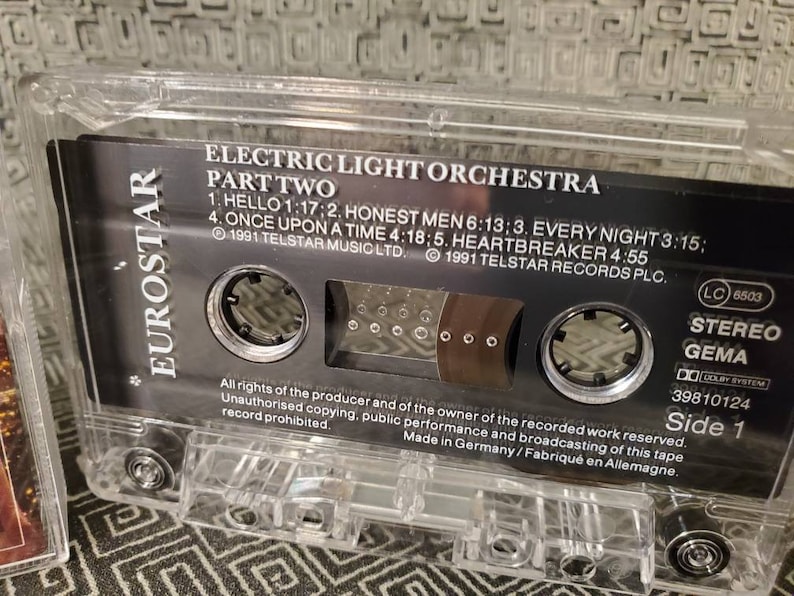 May include: A black cassette tape with a clear plastic case. The tape is labeled "Electric Light Orchestra Part Two" and includes the song titles "Hello", "Honest Men", "Every Night", "Once Upon A Time", and "Heartbreaker". The tape is a stereo recording and was made in Germany.