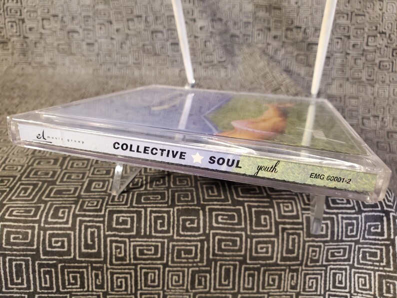 May include: A clear plastic CD case with a blue and green CD inside. The CD case has the text "Collective Soul" and "youth" printed on it. The CD case also has the text "EMG 60001-2" printed on it.