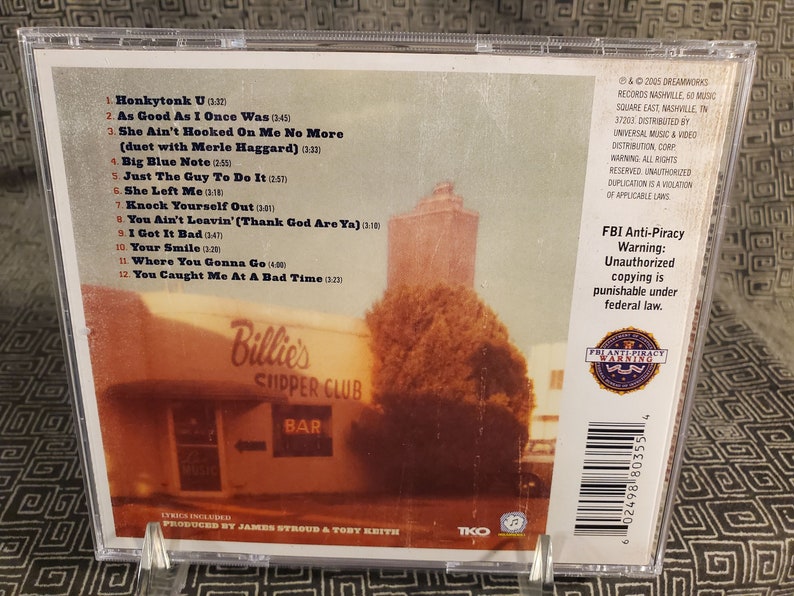 Może przedstawiać: Pudełko na płytę CD ze zdjęciem budynku z napisem "Billie's Chipper Club". Na tylnej stronie pudełka wymieniono tytuły utwor&oacute;w "Honkytonk U" i "As Good As I Once Was", a także umieszczono ostrzeżenie przed nielegalnym kopiowaniem.