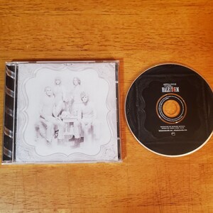 May include: A Halestorm Strange Case CD in a clear plastic jewel case with a black and white cover featuring a band portrait. The disc is black with white text including the band name and album title, centered on a gold-colored inner ring.