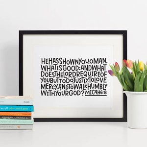 May include: A black framed print with white background and black text that reads "HE HAS SHOWN YOU, O MAN, WHAT IS GOOD: AND WHAT DOES THE LORD REQUIRE OF YOU BUT TO DO JUSTLY, TO LOVE MERCY, AND TO WALK HUMBLY WITH YOUR GOD? MICAH 6:8"