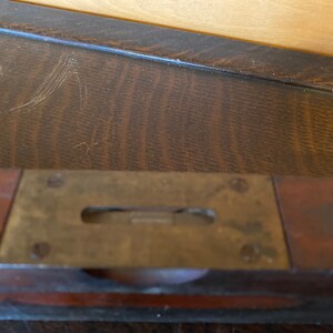 May include: A vintage wooden level with a brass level indicator. The level is made of dark wood and has a brass strip with a level indicator in the center.