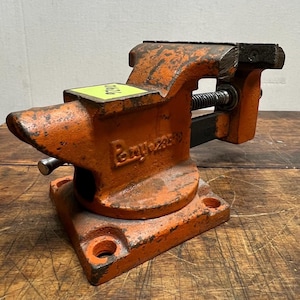 May include: An orange metal vise with a black handle and a silver screw. The vise is labeled "Boyar-Schultz".