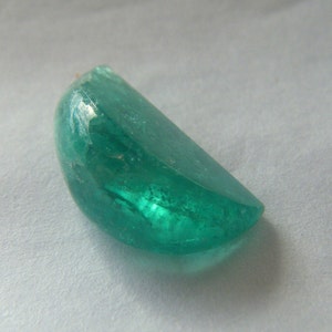 Loose emerald genuine gemstone cut in a unique 'orange section' shape, with a highly polished, cabochon finish.