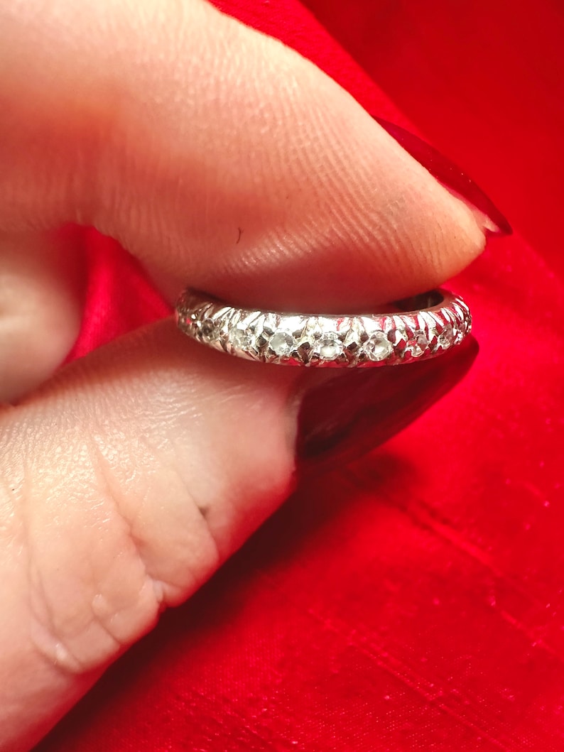 The sides of the solid platinum band are accented with hand engraving, in a vintage Art Deco style.
