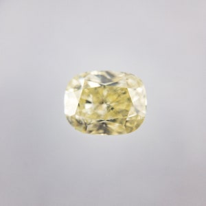 May include: A pale yellow oval-shaped diamond gemstone with a faceted cut.