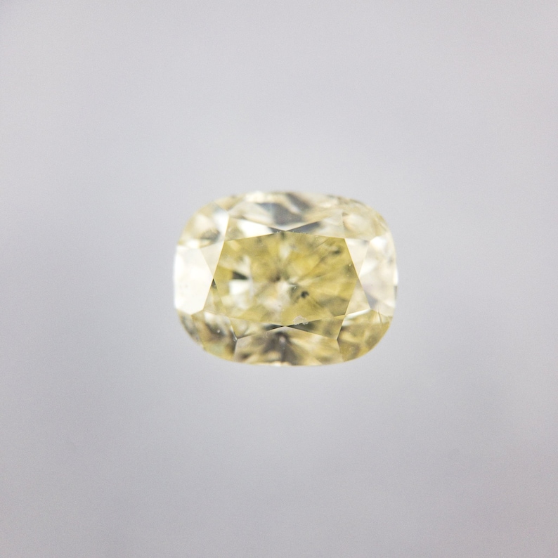 May include: A pale yellow oval-shaped diamond gemstone with a faceted cut.