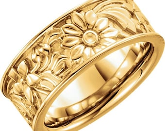 May include: A gold band ring with a floral design. The band is wide and the flowers are raised and detailed.