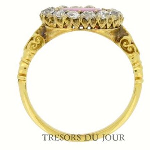Peut inclure: Bague en or avec une pierre rose entour&eacute;e d'un halo de diamants. Le corps de la bague est en or uni, avec des d&eacute;tails d&eacute;coratifs pr&egrave;s du sertissage. La bague est sur fond blanc. Le texte "TRESORS DU JOUR" est visible.