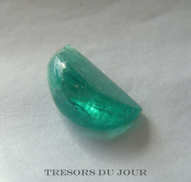 Loose emerald genuine gemstone cut in a unique 'orange section' shape, with a highly polished, cabochon finish.