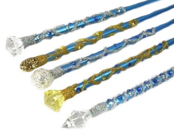 Puede incluir: Cinco varitas azules con purpurina plateada y detalles azules y dorados. Las varitas tienen diferentes puntas de cristal.