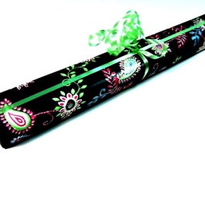 May include: A black gift box with a green ribbon and a floral pattern. The pattern features pink, green, and blue flowers.