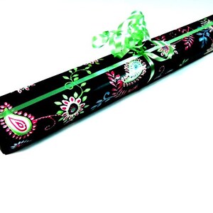 May include: A black gift box with a green ribbon and a floral pattern. The pattern features pink, green, and blue flowers.