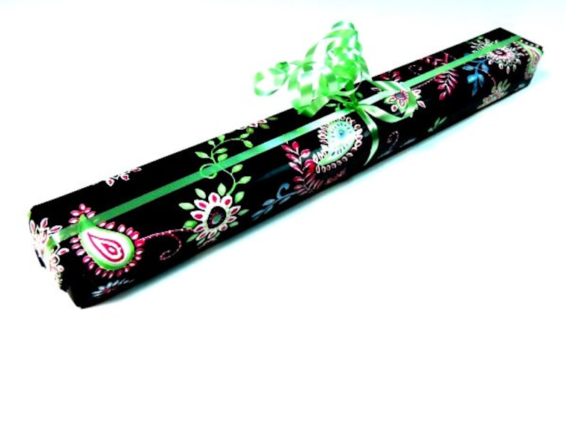 May include: A black gift box with a green ribbon and a floral pattern. The pattern features pink, green, and blue flowers.