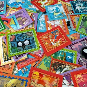 May include: A collection of colorful trading cards featuring various characters and designs. The cards have a postage stamp-like border and include text such as character names and numbers. The cards are scattered, creating a visually engaging display.