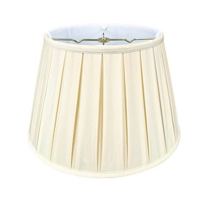 May include: A cream-colored pleated lampshade with a white lining. The lampshade is round and has a smooth, even texture.