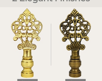 May include: Two decorative lamp finials in ornate designs, one in polished brass and the other in antique brass.  The finials are in the shape of a stylized flower with intricate details.