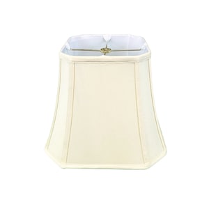 May include: A cream-colored, square-shaped lampshade with a slightly flared bottom. The shade is made of fabric and has a white lining.