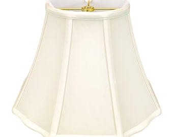 May include: A white, pleated lampshade with a scalloped edge. The shade is made of fabric and has a brass finial.