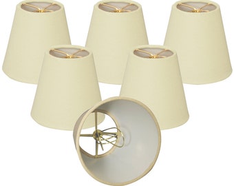 May include: Set of six off-white fabric lampshades with a gold metal frame. The lampshades are in a cone shape.