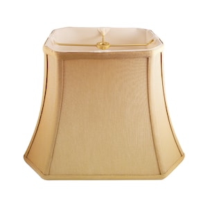 May include: A square-shaped lampshade with a beige fabric exterior and a white fabric lining. The lampshade has a slightly flared shape and a gold metal frame.