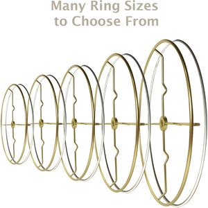 May include: A set of six gold and silver lampshade rings in various sizes. The rings are arranged in a row from smallest to largest.