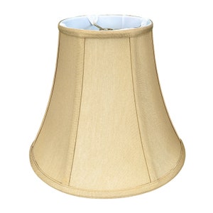 May include: A beige lampshade with a bell shape and a white lining. The lampshade has a simple design with a smooth fabric texture.