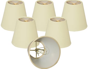 May include: Set of six off-white fabric lampshades with a gold metal frame. The lampshades are in a cone shape.