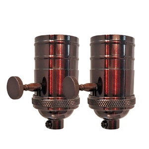 May include: Two antique bronze finish light bulb sockets with side switches. The sockets have a threaded base for mounting.