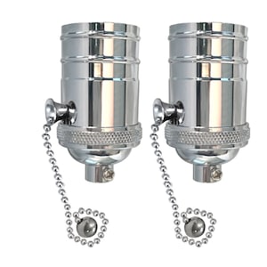 May include: Two chrome light bulb sockets with pull chains. Each socket has a threaded base and a pull chain with a round ball at the end.