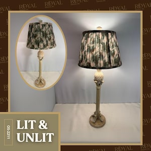 May include: A decorative table lamp with a cream-colored base and a patterned lampshade. The lampshade features a green and pink floral design. The lamp has a pineapple-shaped detail on the stem. The image also includes the text "LIT & UNLIT".
