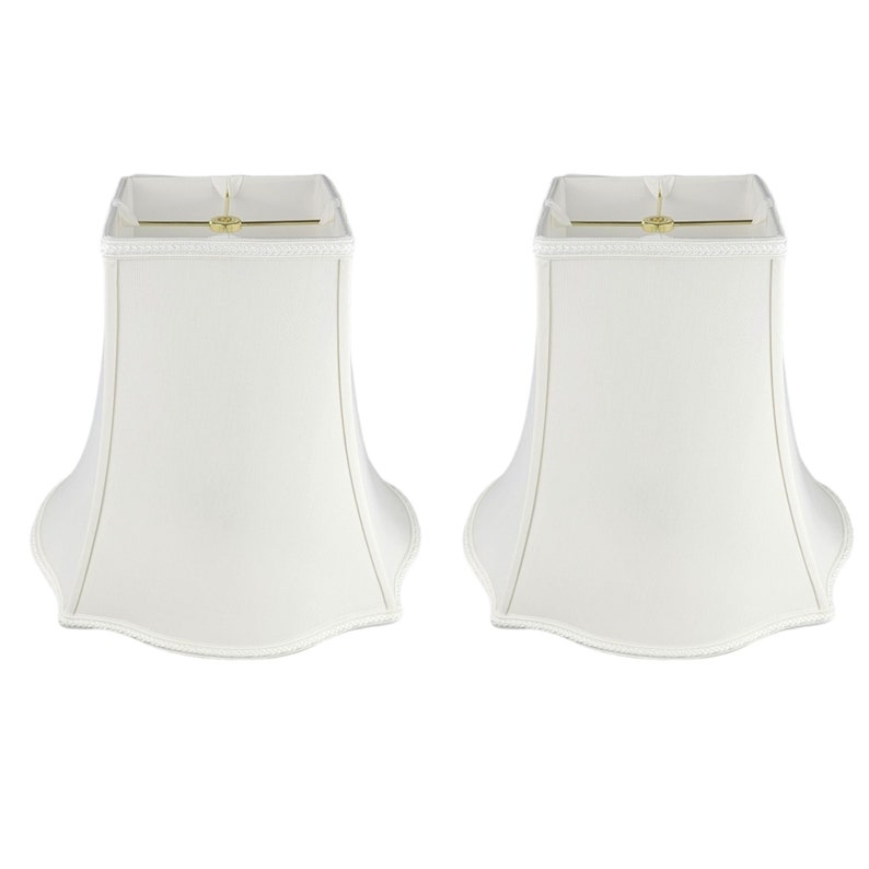 May include: Two white lampshades with a scalloped bottom edge. The lampshades are square at the top and have a bell shape.
