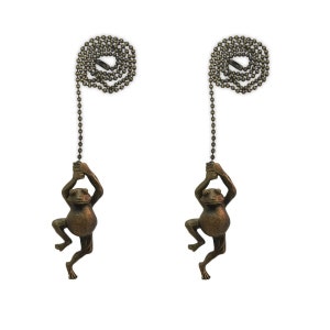 May include: Two bronze frog-shaped light pull chains with a beaded chain.